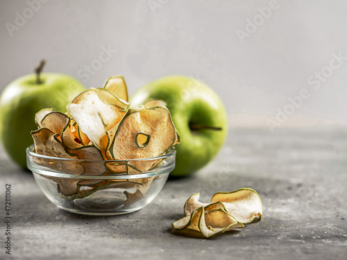 Apple chips on a gray background. The concept of healthy eating.