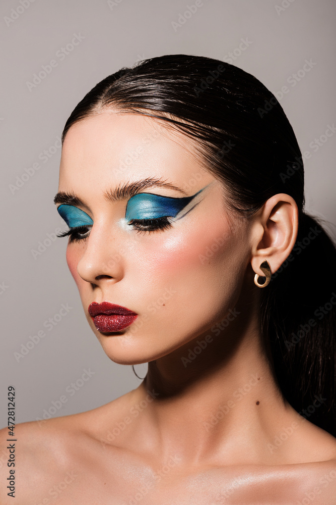 Fototapeta premium Brunette girl, photo portrait, with bright beautiful makeup, with blue eyelids