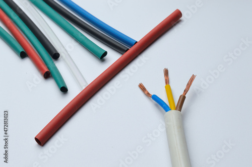 heat shrink tubing and a three-core stripped wire on a white background.