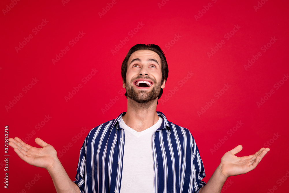 Photo of impressed guy look empty space low prices ads promo fall isolated over red shine color background Photo of impressed guy look empty space low prices ads promo fall isolated over red shine color background