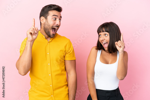 Young couple isolated on pink background intending to realizes the solution while lifting a finger up