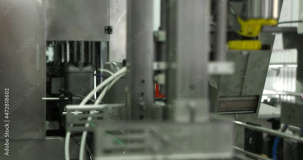 Machine oil production plant. Gray plastic bottles move along a conveyor line to fill and pack motor oil. Development, storage and supply of lubricants for industrial enterprises. RED camera. Machine oil production plant. Gray plastic bottles move along a conveyor line to fill and pack motor oil. Development, storage and supply of lubricants for industrial enterprises. RED camera.