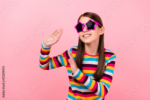 Photo of funny little lady dance have carefree fun wear star sunglass striped shirt isolated pink color background