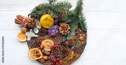 traditional Wiccan altar for Yule sabbath. Sun-moon amulet, wheel of the year, gemstones, cinnamon, nuts, cones, dry orange slices. Esoteric Ritual for Christmas, Yule, Magical Winter Solstice photo