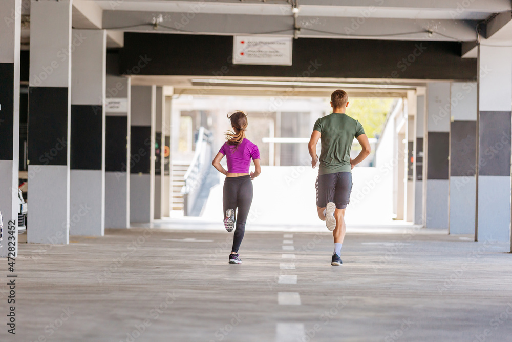 Fototapeta premium Sport couple run together in park. Young people jogging together at fitness training outdoor. Man and woman at sport training together