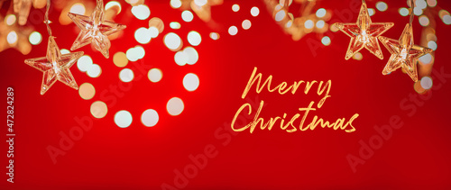 Fototapeta Naklejka Na Ścianę i Meble -  String of star shaped Christmas lights on red background. Holiday decoration. Merry Christmas writing