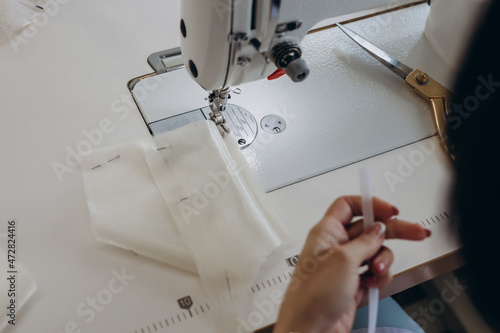 A creative master is making dress on the dressmaking table.