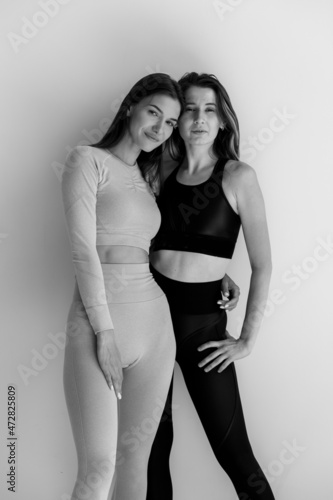 Two sports girls posing isolated on a white background. Fitness model woman in studio with copy space
