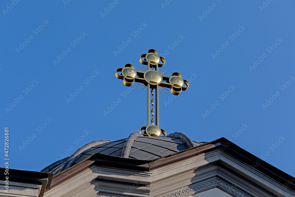 Yellow cross on the roof of the church