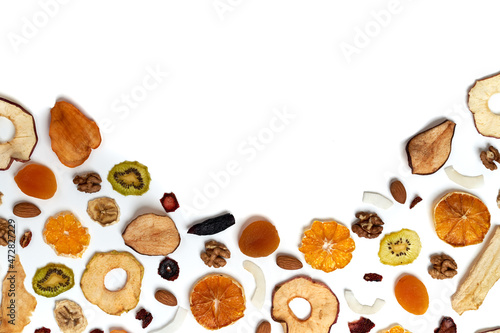 Obraz na plátně Above view composition of dried fruits apples, orange, persimmon, kiwi, apricots and nuts on white background