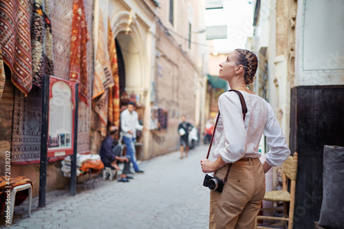 Tourism and technology. Happy young woman taking photo of Marrakesh old town. Traveling by Morocco.