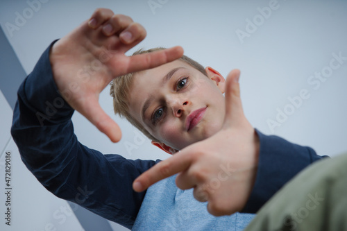 portret chłopaka wykonującego gesty dłonią 