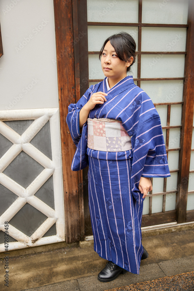 日本の屋敷の前に立つ着物を着た日本人女性