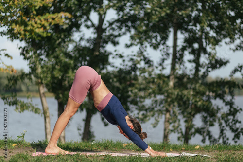 strong and beautiful girl in sportswear doing yoga poses in the park, balance, fitness, stretching and relaxation 