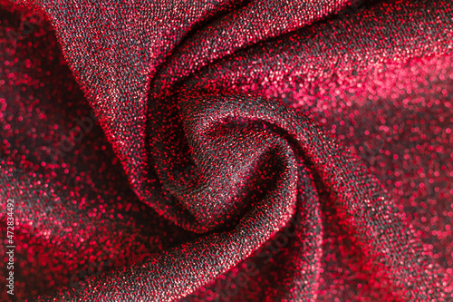 Shiny surface of red and black fabric with lurex