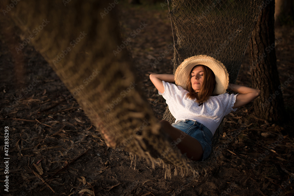Young woman relaxing lying on knitted hammock Young woman relaxing lying on knitted hammock