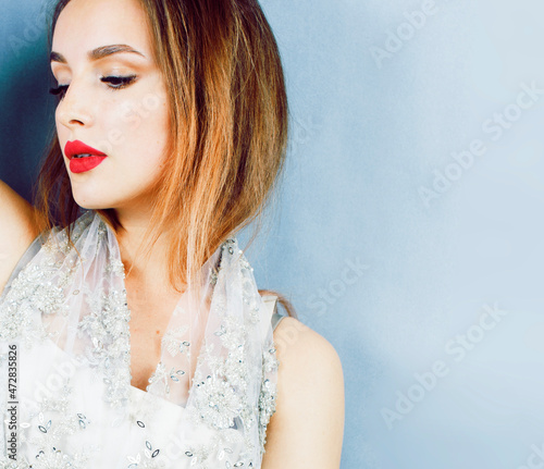 young pretty woman with blond hair on blue background, sensual make up elegant look