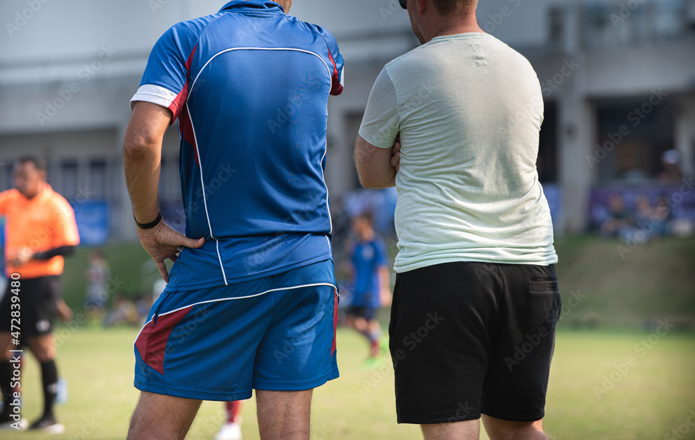 Fototapeta premium Head football coach discusses with his staff coach during a match in a high school soccer tournament.
