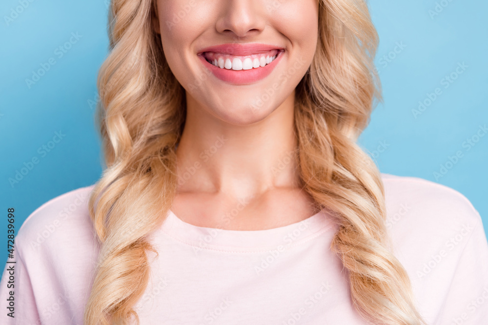 Cropped photo smiling woman with curly blonde hair got veneers isolated pastel blue color background Cropped photo smiling woman with curly blonde hair got veneers isolated pastel blue color background