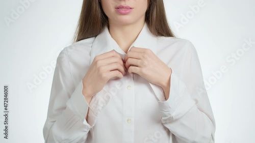 Sexy woman undresses unbuttoning the buttons on a white business shirt. Cheating concept at work. Close-up of cropped arms.