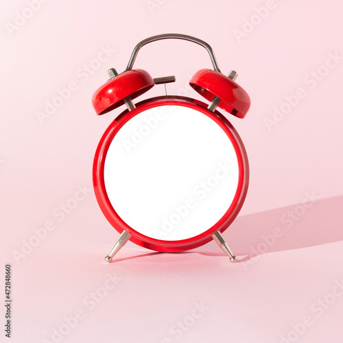 Red alarm clock with empty space on pink pastel background. Copy space for morning messages. Minimal concept. Wake up call.
