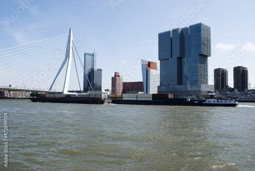 Erasmusbrug in the center of Rotterdam over the river Nieuwe Maas with a large cargo ship in the Netherlands