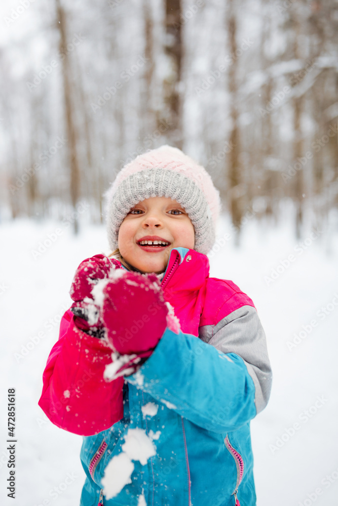 A young girl have fun playing snowballs in winter, in a positive mood A young girl have fun playing snowballs in winter, in a positive mood