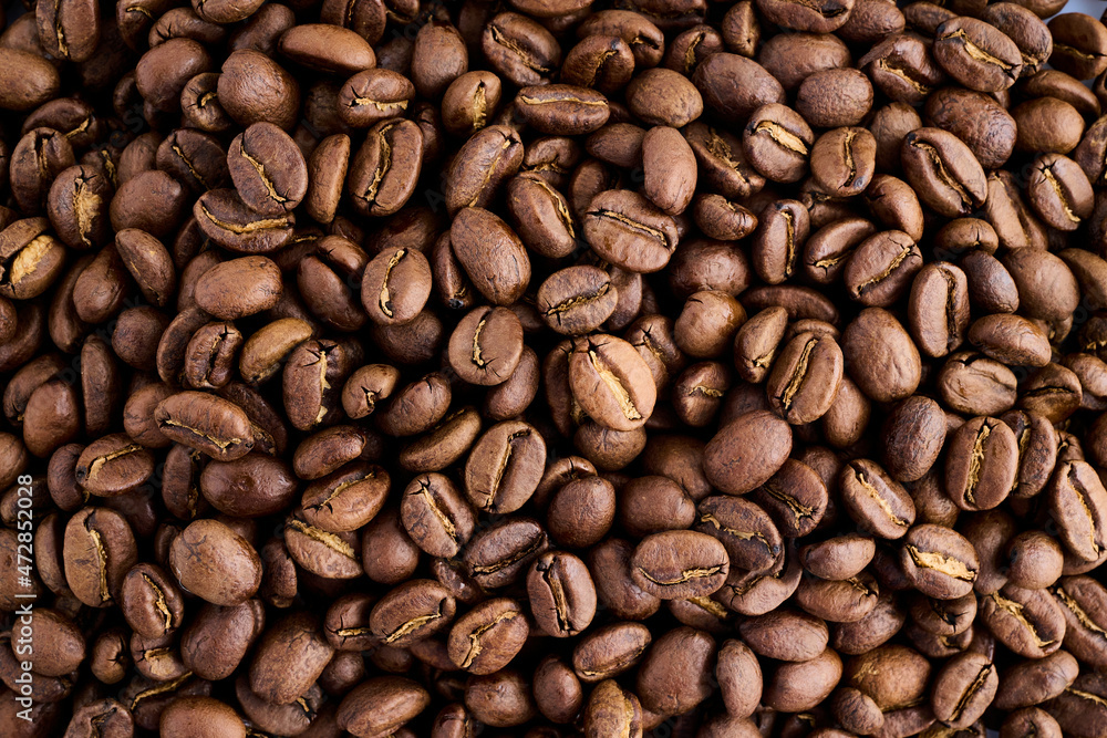 Closeup of dark coffee arabica beans texture. Caffeine aroma. Pile of scented black grains Closeup of dark coffee arabica beans texture. Caffeine aroma. Pile of scented black grains
