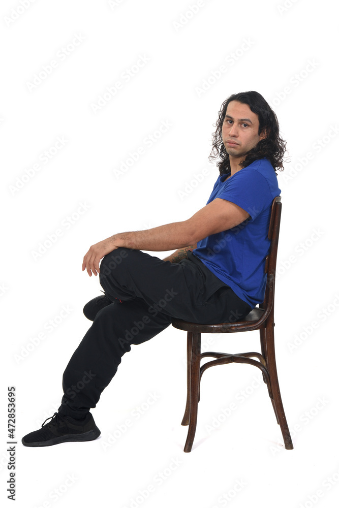 side view of a man with sportswear sitting on chair looking at camera on white background side view of a man with sportswear sitting on chair looking at camera on white background