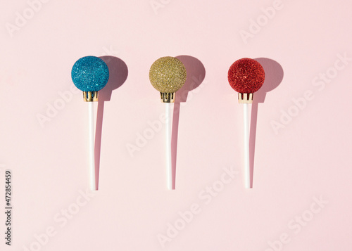 Lollipops made of New Year's balls. Minimal concept of Christmas candy.