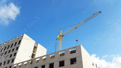 construction crane over high building and blue sky