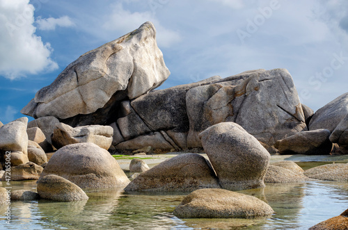 Granite boulders against the blue cloudy sky.