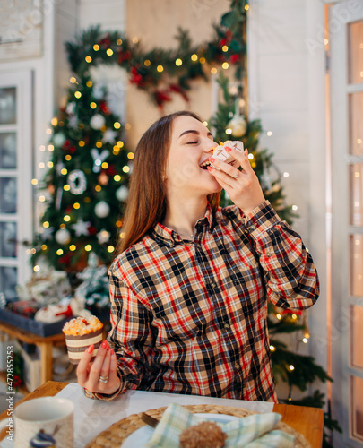 girl eating christmas dessert in festive decorated room