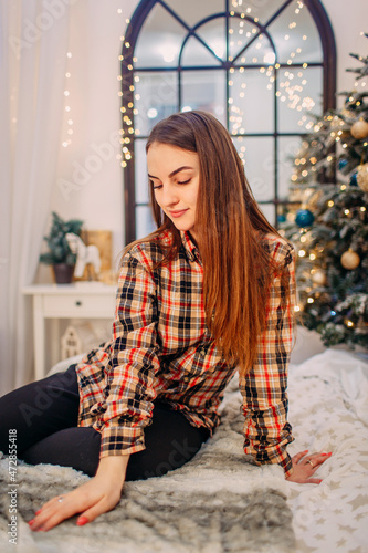 girl sitting in christmas decorated room and wishing