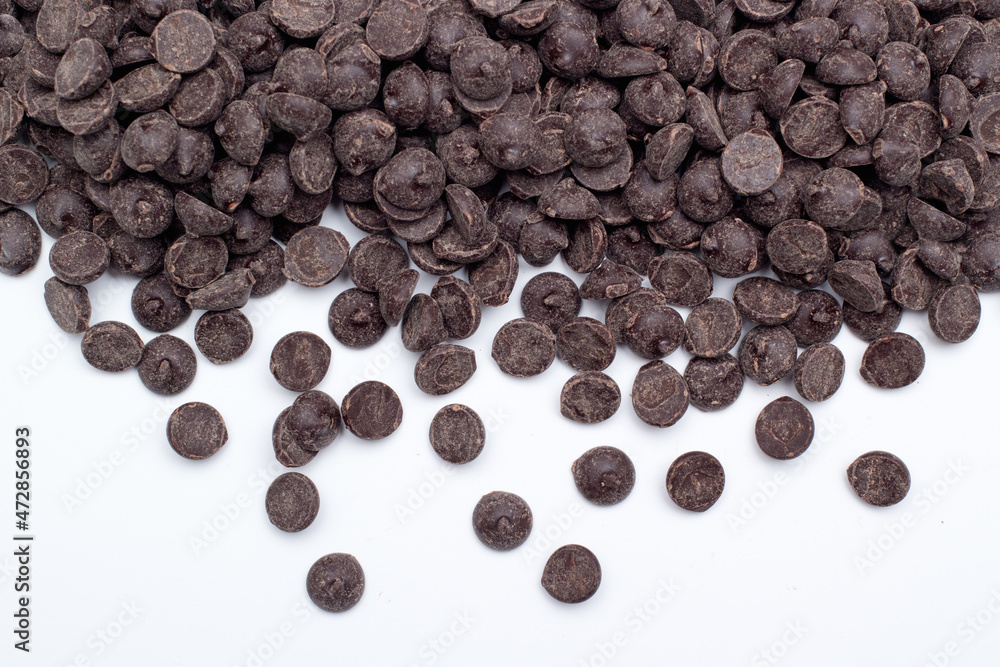Heap of sweet tasting chocolate chips on white Heap of sweet tasting chocolate chips on white