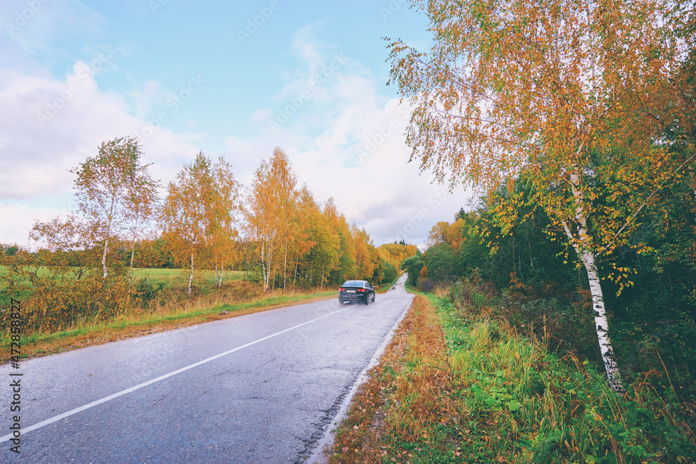 Fall season. Beautiful landscape with car on the road.