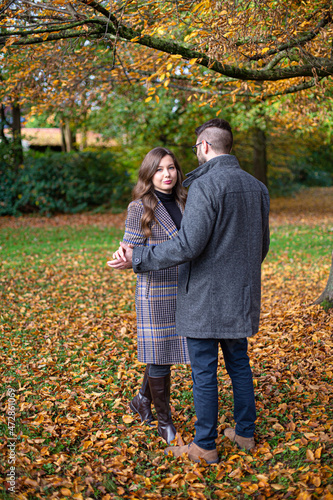 Embracing white young european man and woman in autumn forest