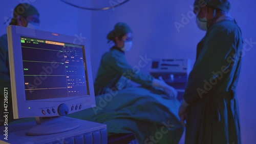 Surgeon team in uniform is shutting light and covering patient dead body after unsuccessful surgery in operation and died patient in bed and monitor showing heart rate in operating room at hospital. 