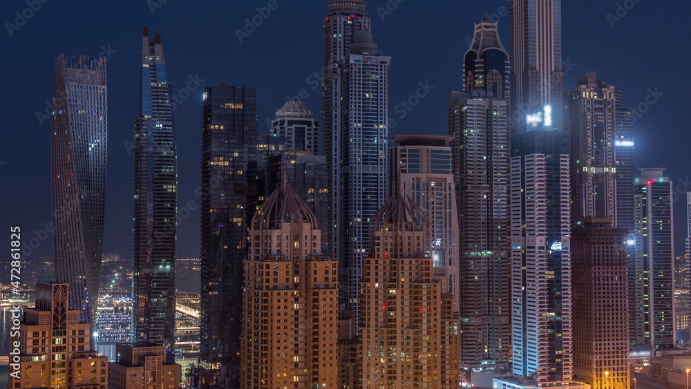 Naklejka premium Skyscrapers of Dubai Marina near intersection on Sheikh Zayed Road with highest residential buildings night to day timelapse