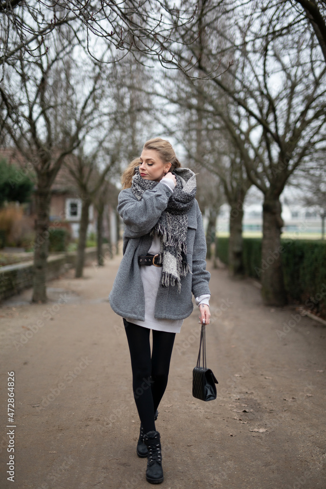 Wunderbare Schöne Frau mit Blondem Haar und Grauen Mantel in der Winter Zeit in Berlin Grüner Sport Platz Wunderbare Schöne Frau mit Blondem Haar und Grauen Mantel in der Winter Zeit in Berlin Grüner Sport Platz