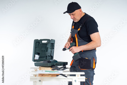 A man in work clothes is ho...