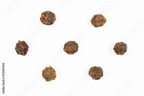 Group of seven whole spicy black pepper isolated on white background