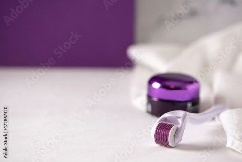 purple face roller ith cosmetic cream photo