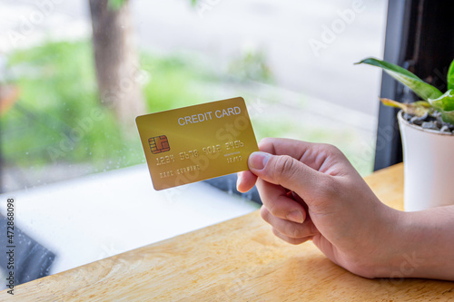 Women holding a yellow gold credit card to shop online, credit cards can accumulate points to use points for online shopping, credit cards to use installments.