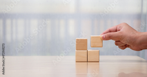 Businessman arrange wooden blocks stacked in uneven steps like obstacles, business growth journey success concept.