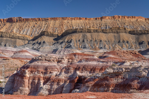 USA, Utah, Wayne County. North Cainevile Mesa, composed of Mancos Shale, rises above layers of bentonite clay. photo