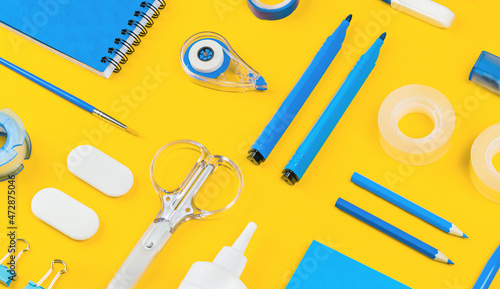 Photos Assorted office and school white and blue stationery on bright yellow background
