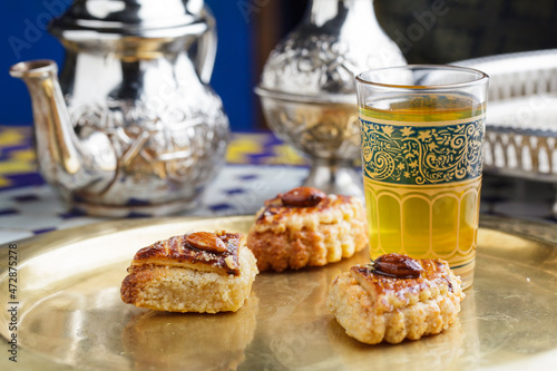 Moroccan almond pastries with mint tea on a golden tray photo