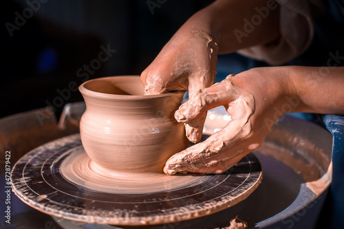 Creating a jar or vase. Master crock. Making clay jug. The sculptor in the workshop makes a jug out of earthenware closeup. Potter's wheel. Pottery concept.