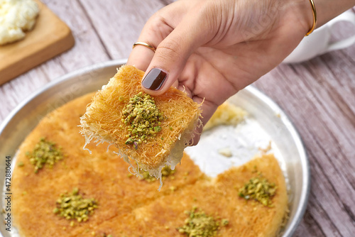 Arabian Traditional Desserts - Cream and cheeses with pistachio flavor and nuts topping on gray background